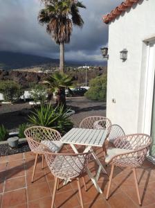 een tafel en stoelen op een patio met een palmboom bij Cráter 1 in El Paso