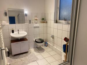 ein weißes Bad mit einem Waschbecken und einem WC in der Unterkunft Ferienwohnung Wuppertal Ronsdorf Elias Eller in Wuppertal