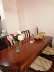una mesa de madera con flores en un jarrón. en Апартамент за гости Мая Downtawn Банско, en Bansko