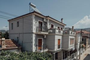 een groot wit gebouw met balkons in een straat bij Guesthouse Sara & Esi in Korçë