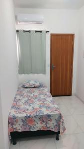 a bedroom with a bed and a wooden door at Suítes Privativas em Guriri in Guriri