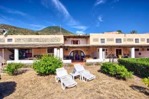 a group of lawn chairs in front of a house at Le case di Eolo - Lingua - Isola Salina in Lingua
