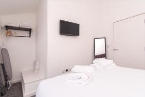 a white room with a bed and a mirror at Cricket View - Fabulous 1bed Apt near Trent Bridge Cricket Ground in Nottingham