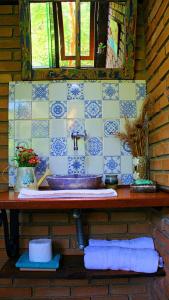 baño con lavabo y azulejos azules y blancos en Hospedagem EXCALIBUR, en Visconde De Maua