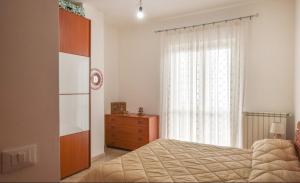 1 dormitorio con 1 cama, vestidor y ventana en Confortevole e Spazioso Appartamento 100mq a Falerna con Vista Panoramica sul Golfo con Free WiFi e Smart Tv, en Falerna