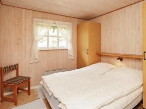 JerupにあるThree-Bedroom Holiday home in Jerup 13のベッドルーム1室(ベッド1台、椅子、窓付)