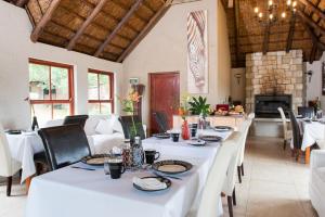 une salle à manger avec des tables et des chaises blanches dans l'établissement Strawberry Fields Country Manor Guest House, à Johannesbourg