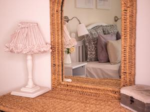 uno specchio in una stanza con un letto e una lampada di Provance Apartment a Liepāja Altre 13 foto