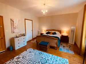a bedroom with a bed and a dresser at Le Portanel in Eymet