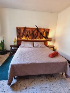 a bedroom with a large bed with a wooden headboard at ESTU habitaciones in Guatemala