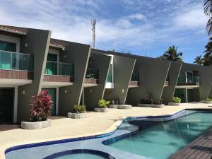 ein Hotel mit einem Pool vor einem Gebäude in der Unterkunft Flat porto de galinhas in Porto De Galinhas