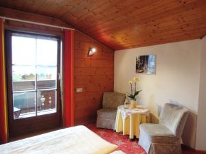 Zimmer mit einem Bett, 2 Stühlen und einem Fenster in der Unterkunft Haus Carina in Flachau