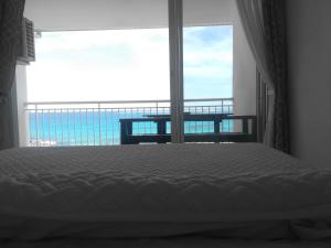 
a bed in a hotel room with a view of the ocean at Happy Residence - Orient Beach 11 in Saint Martin

