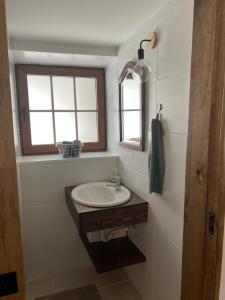 baño con lavabo y ventana en Nocas House, en Fojo