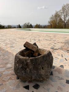 un tazón de piedra sentado en el suelo en un parque en Nocas House, en Fojo