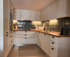 una cocina blanca con armarios blancos y fregadero en Nocas House, en Fojo