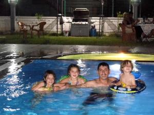 a man and two children in a swimming pool at Pusula Apart Otel in Antalya