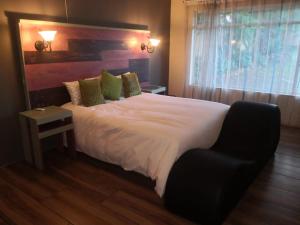 a bedroom with a large white bed with a window at 15 On Reitz Bela bela in Bela-Bela