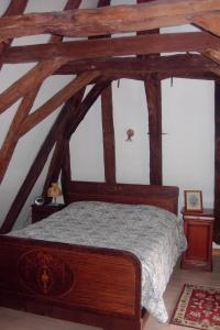a bedroom with a wooden bed in an attic at Chambres d'Hôtes & Gites Pouget in Les Eyzies-de-Tayac