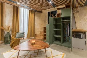 - un salon avec une table en bois et une armoire verte dans l'établissement LA Sainte Catherine 264, à Bordeaux 8 autres photos