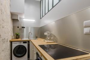 une cuisine avec un évier et une machine à laver dans l'établissement LA Sainte Catherine 264, à Bordeaux
