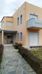 a house with a stone walkway in front of it at Villa Katerina in Ialyssos