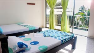 een kamer met 2 bedden en een raam met een balkon bij Hotel Reserva Aguamarina in Playa Ladrilleros