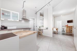 een witte keuken met witte kasten en een tafel bij Casa da Suite Splendida in Milaan