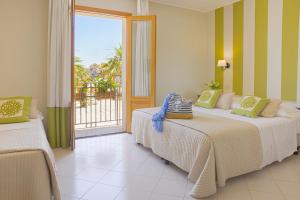 a bedroom with two beds and a large window at Hotel Al Madarig in Castellammare del Golfo