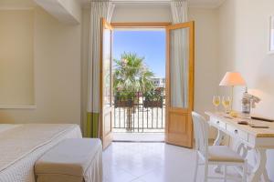 a hotel room with a bed, table and a window at Hotel Al Madarig in Castellammare del Golfo