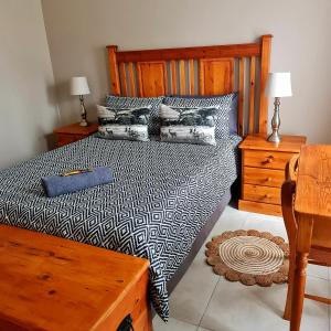 a bedroom with a bed with a black and white comforter at 44 on Ribbok Selfcatering House in George