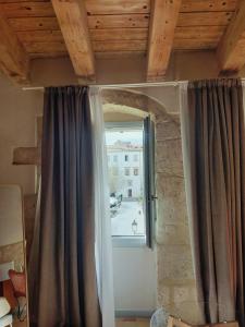 a window in a room with a curtain at Locanda Carra Manna in Sassari