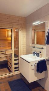 uma casa de banho com um lavatório branco e um chuveiro em Bord de lac - 4/6pers SAUNA - terrasse 20m2 em Vielsalm