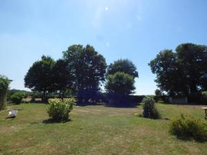 a park with trees and a bench in a field at la pause campagne in Pullay
