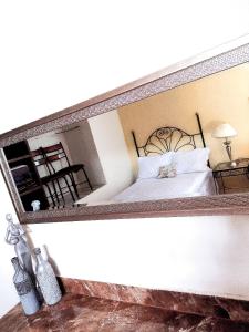 a mirror above a bed in a bedroom at Casa Pueblo bonito in Bernal