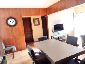 a dining room with a table and a clock on a wall at Casa Pueblo bonito in Bernal +11 photos