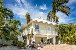 a house with palm trees in front of it at Skyway Living in Summerland Key