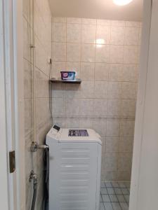 a bathroom with a toilet and a tiled wall at Alexi Apartments - Newly Renovated Apt in the Heart of the City near to Railway Station and Nokia Arena in Tampere