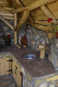 eine Theke aus Stein mit einem Waschbecken im Zimmer in der Unterkunft Vila Šapat šume in Ljuboš