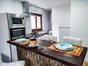 a kitchen with a table with two plates and wine glasses at Casa Liberatina in Cudillero