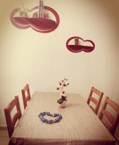 a dining room table with a necklace and flowers on it at Piccola Pisa (zona Ospedale Cisanello) in Pisa