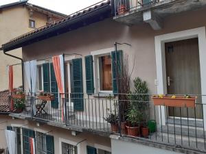 un edificio con persianas verdes y macetas en un balcón en Piazza Grande House en Locarno