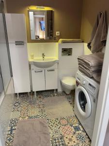 łazienka z umywalką i pralką w obiekcie Apartament Kiekrz w mieście Baranowo