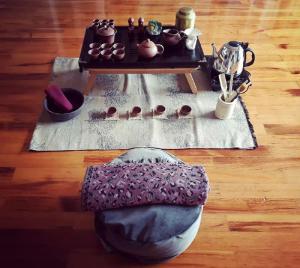 a table with tea pots and a bench on a wooden floor at Urban Yoga House Hostel & Retreat in Ioannina