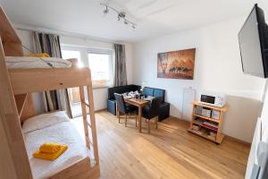 um quarto com um beliche e uma secretária com uma mesa em Alpin Apartments em Maria Alm am Steinernen Meer
