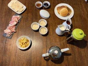 a table topped with plates and bowls of food at Maison 2 chambres avec espace extérieur privé et petit-déjeuner en supplément - fait-maison et produits locaux in Vierville-sur-Mer