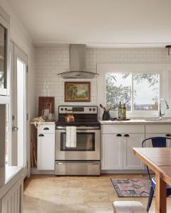a kitchen with a stainless steel stove and white cabinets at Gran Roble in Waupoos