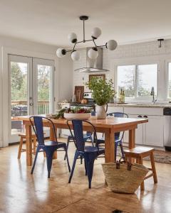 een keuken met een houten tafel en blauwe stoelen bij Gran Roble in Waupoos