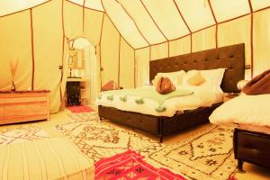 a bedroom with a bed in a tent at Sunset luxury camp in Hassilabied