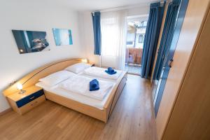 A bed or beds in a room at Alpin Apartments